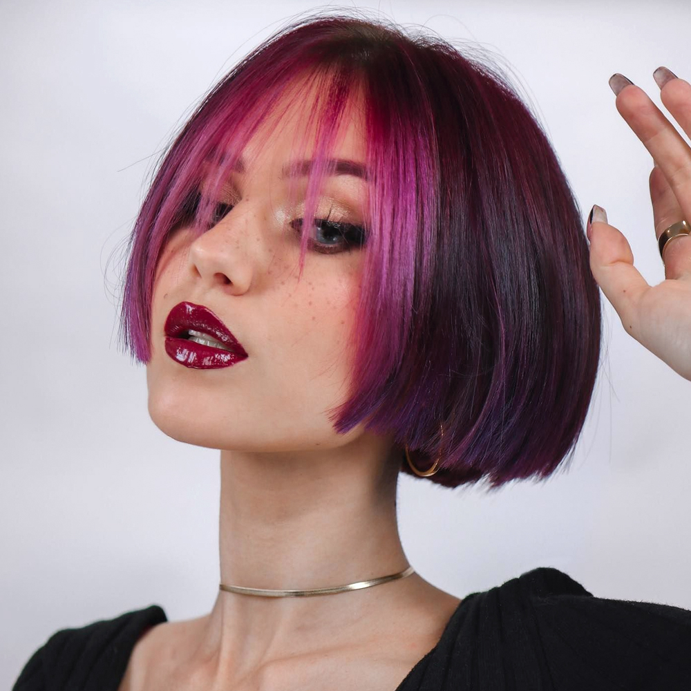 a portrait of a young woman with a short bob pink hair