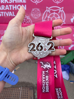 The Yorkshire Marathon medal which says 26.2 with a floral background.