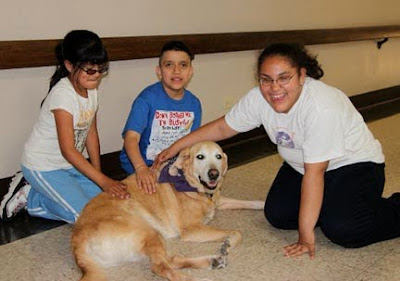 Youth participants in a GDB Lifestyles Workshop, happily petting a yellow Lab