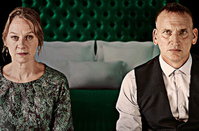 photo of Nimh Cusack and Christopher Eccleston seated on a bed (as  Lady Macbeth and Macbeth)