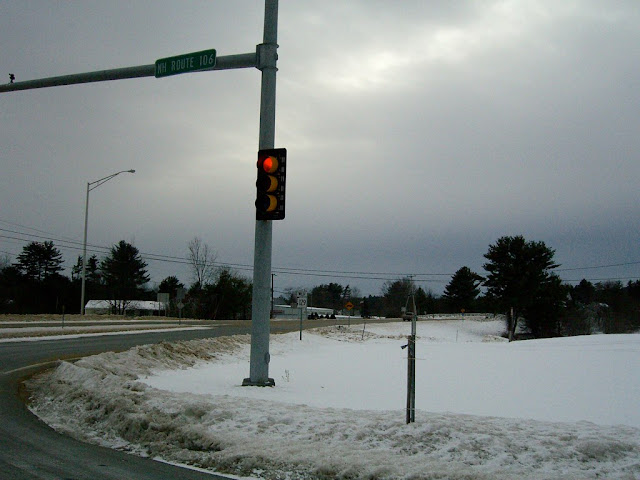 Stop light at a snow-covered intersection in New Hampshire.