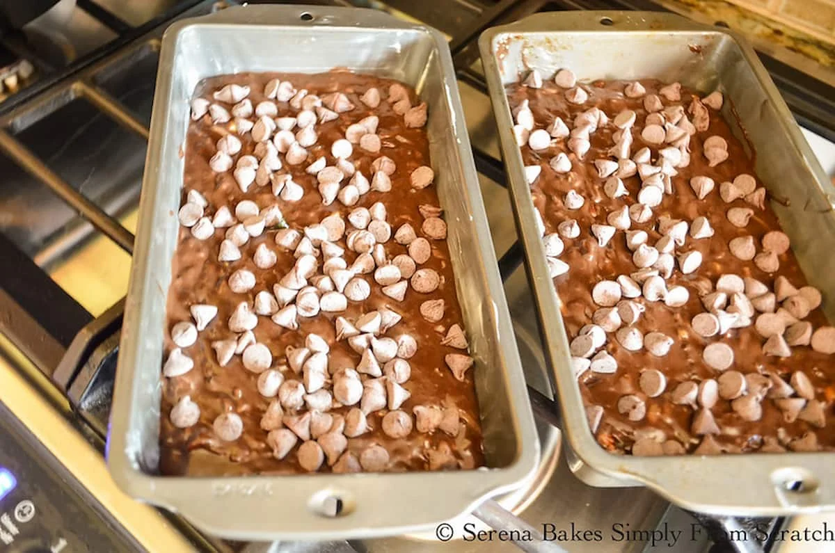 Chocolate Zucchini Bread batter divided between 2 bread pans and topped with chocolate chips.