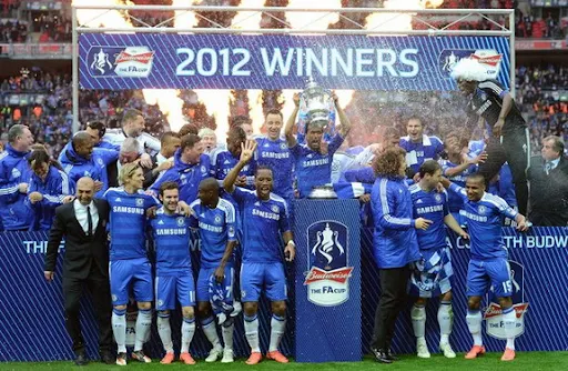 Chelsea players celebrate on the pitch after winning the FA Cup