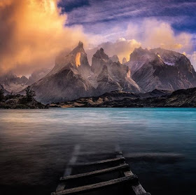 Picture of mountains on Lake Pehoe, Chile, with a ladder or bridge submerged in the water.