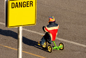 MYNTCC, New Testament Christian Churches of America, Inc., NTCC St. Louis, MO; NTCC Graham, WA.  A child in danger rides a tricycle on the side of a road.  You wouldn't endanger your child by placing him or her here; don't endanger your child by placing them or leaving them in the NTCC, which has a history of hiding perverts while demonizing whistle blowers who report the abuse.