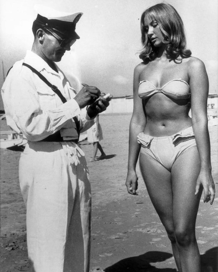 A woman is ticketed for wearing a bikini, 1957.