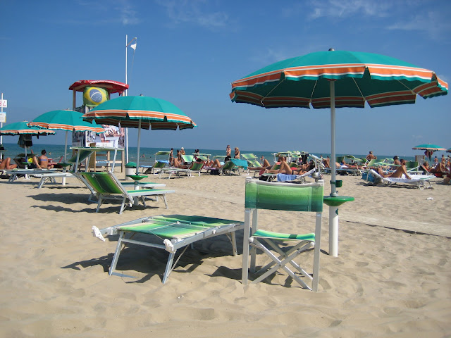 A photo of umbrellas and deck chairs on the beach in Rimini, Italy.