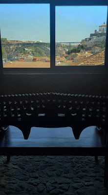 banco de madeira esculpida em frente à janela com vista para a ponte Luis I