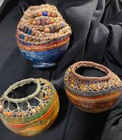 a collection of gourd art projects displayed on fabric