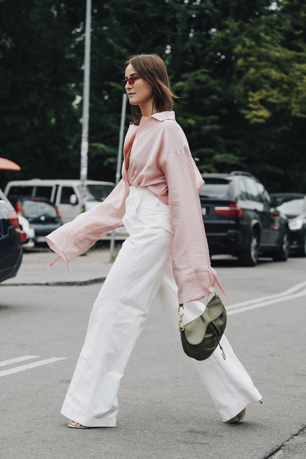 25 Cool Pink Tops to Wear for Spring and Beyond — Street style outfit with a pink button-down, white wide-leg pants, and green Dior saddle bag