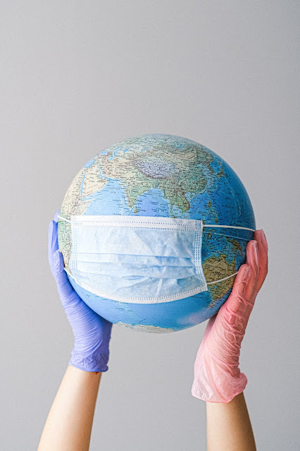 hands holding a globe with mask
