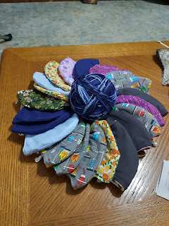 Picture of a fabric masks encircling a ball of blue yarn