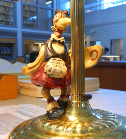 A Hankey Bird figurine attached to the base of a lamp.