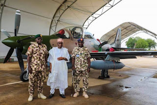 Nigerian Airforce officers pose with one of the A-29 Super Tucano jets