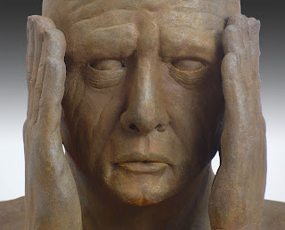 Figurative sculpture by sculptor Dan Woodard of a man holding his hands in front of his face.  Sculpture of clay with a rusted iron coating.