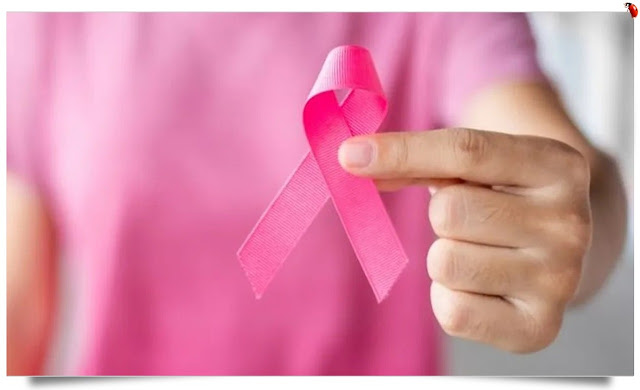Mulher segura na mão a fita rosa símbolo do Cancro da Mama.