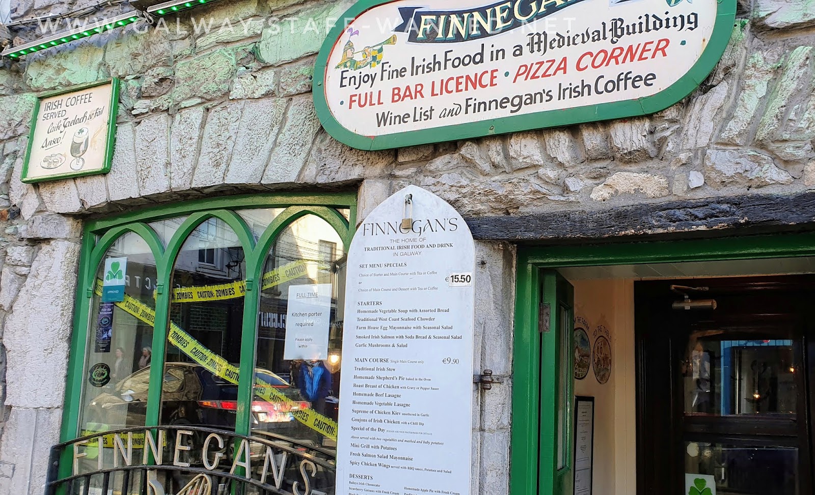 sign in Irish restaurant window with Halloween decorations - and Finnegans restaurant menu board - main €15.50.