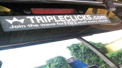 TripleClicks decal on back wind shield of a car.