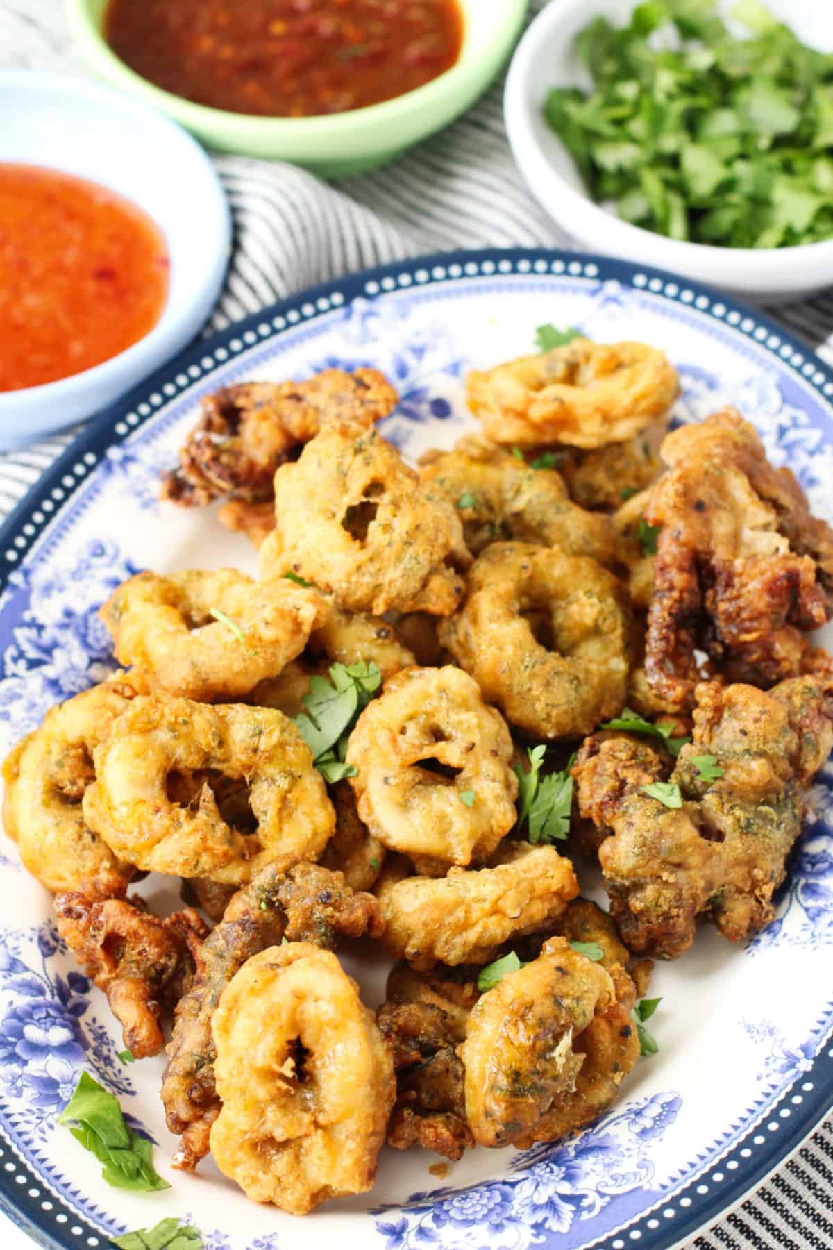 Salt and Pepper Squid with dipping sauces on a platter.
