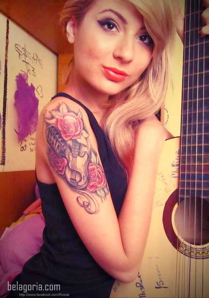 Imagen de una preciosa modelo rubia tatuada con un micrófono en el brazo