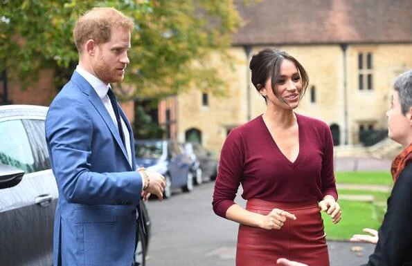 Meghan Markle wore Joseph pullover, Hugo Boss Selrita leather skirt, Sarah Flint pumps and Emily Mortimer Hera gold and diamond earrings