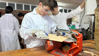Alumno en el taller de tecnología cortando madera