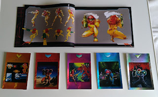artbook and all cards, the opened pages show some old Metroid 1 art and the cards have the cover arts of the five main titles