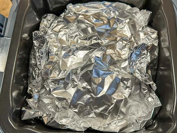 Garlic bread covered in foil ready to air fry.