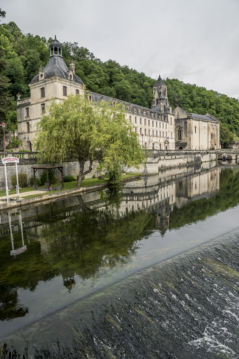 Vista de Brantome, en el Perigord, Francia, del puente de piedra y la abadía benedictina de Saint-Pierre