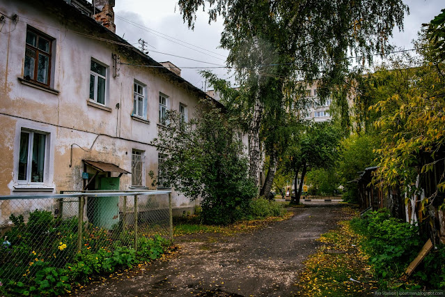 Двор обшарпанного дома с сараями