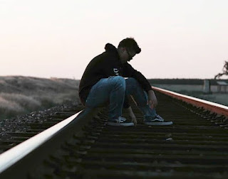 Joven solitario en las vías de un tren