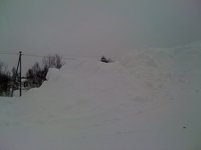 Snødekt Tromsø: gårdsplassen rundt leiligheten vår 26. mars 2011. Snøhaugen ved parkeringsplassen er høyere enn telefonstolpene.