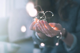 Woman's hands cupping a string of white mini-lights