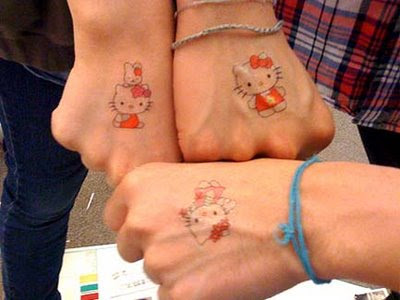 A couple of Hello Kitty fans showing off their Hello Kitty Tattoo Ideas