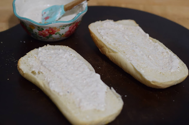 The horseradish mayo being smeared on the bun.