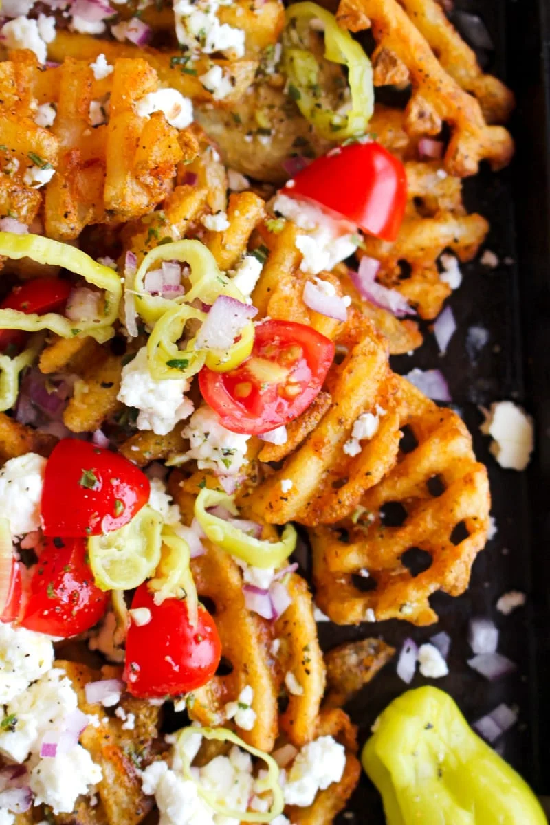 Top view closeup of Greek Waffle Fries on a dark sheet pan.