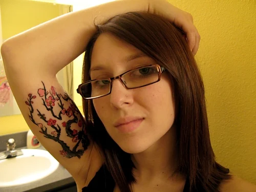 vemos a una modelo joven con un tatuaje en el interior del biceps
