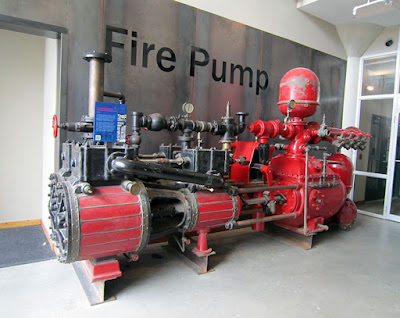 Vintage pump used to fight fires, large and painted red