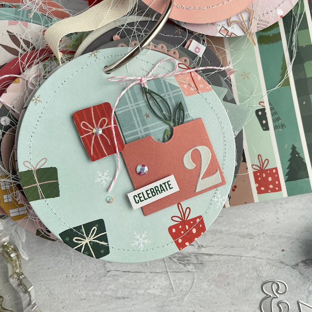 Christmas Advent Calendar Mini Album created with the Scrapbook.com Christmas patterned paper pad, nested decorative circles die, nested tree die, little envelopes die, snowflake die, nested pockets die, nested tags die and more.
