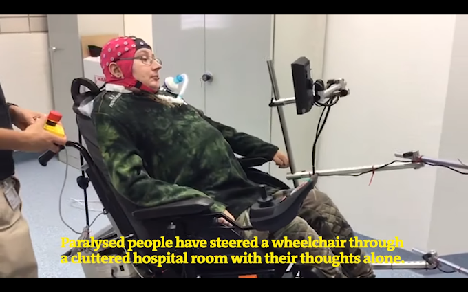People with paralysis use a mind-controlled wheelchair to explore a room.