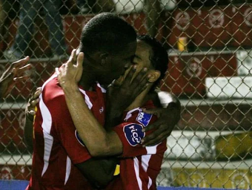 Brayan Beckeles and Orlin Peralta kissing during a goal celebration