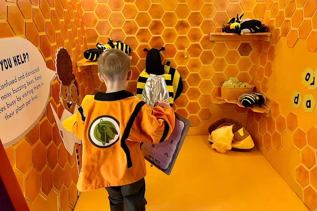 a room made to look like a bee hive with bee costumes, cuddly bees and magnetic letters on the wall