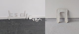 Letters made from wooden board reading 'its all over', letter made from plaster reading 'n'
