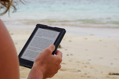 Person reading a Kindle on the beach