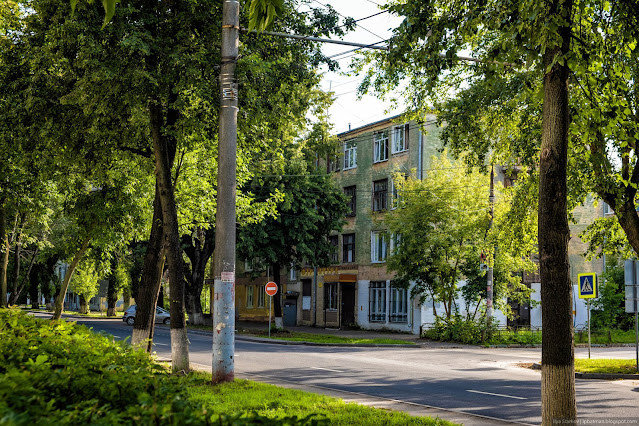 Старое зеленое кирпичное здание за деревьями