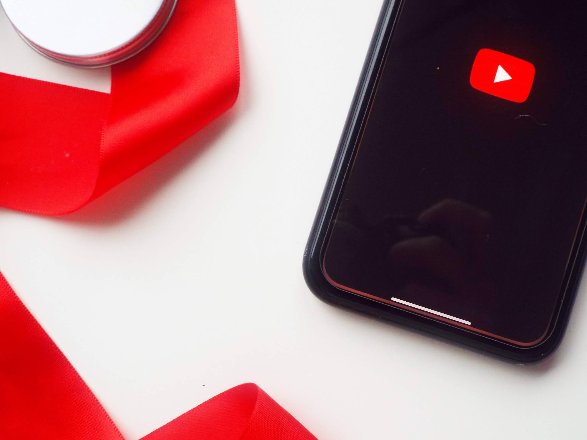 Flatlay of phone with YouTube icon and red ribbon, signifying my two video favouties from January 2021.