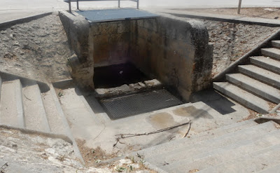 Fuente de piedra en el suelo, dos escaleras de piedra que bajan hacia ellahd esca