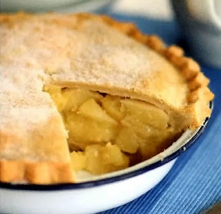 Deep double crust pear and apple pie with a wedge taken out to show the filling