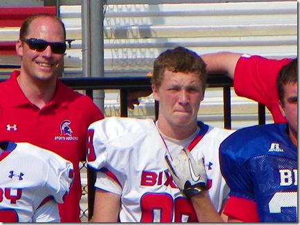 From all the way across the field and up in the bleachers, it seems coach sees a camera pointed in his direction.  Pay attention to the game, Coach!
