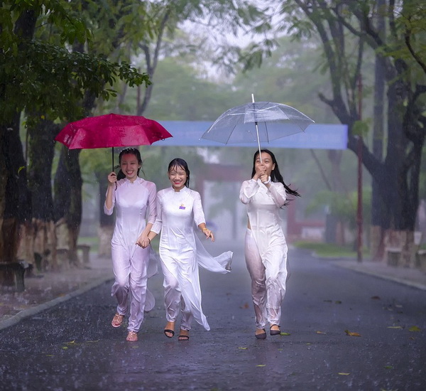 Ba nữ sinh che dù ướt mưa